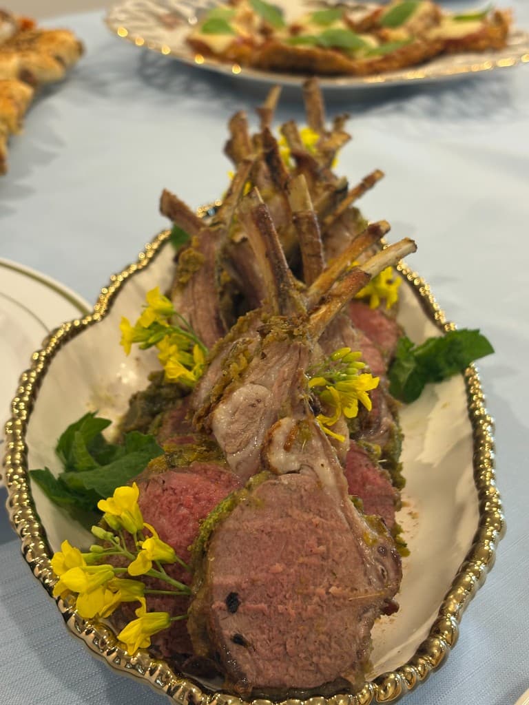 Herb-crusted rack of lamb served on an ornate platter