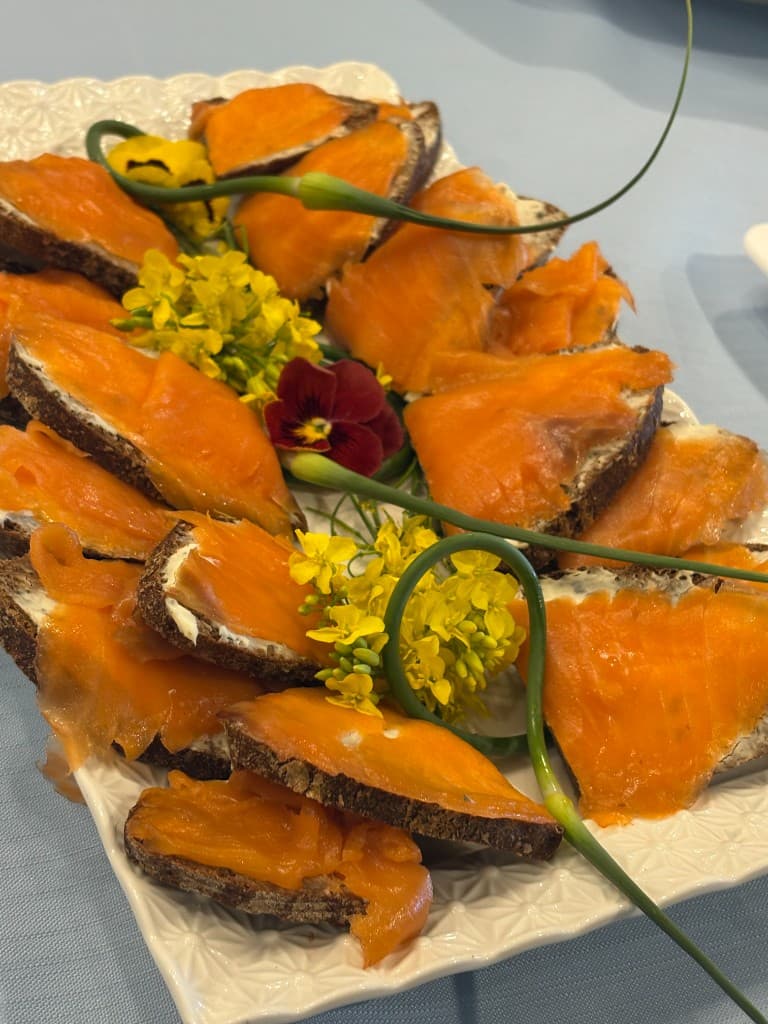 Smoked salmon canapes arranged with herbs and edible flowers