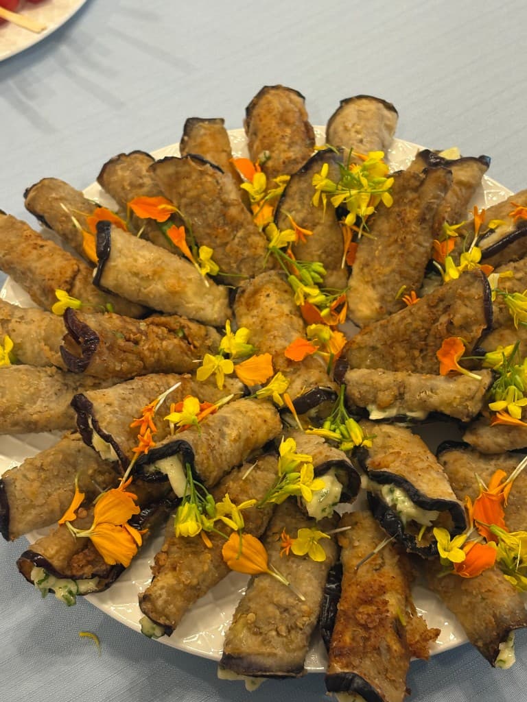 Stuffed eggplant rolls garnished with edible flowers
