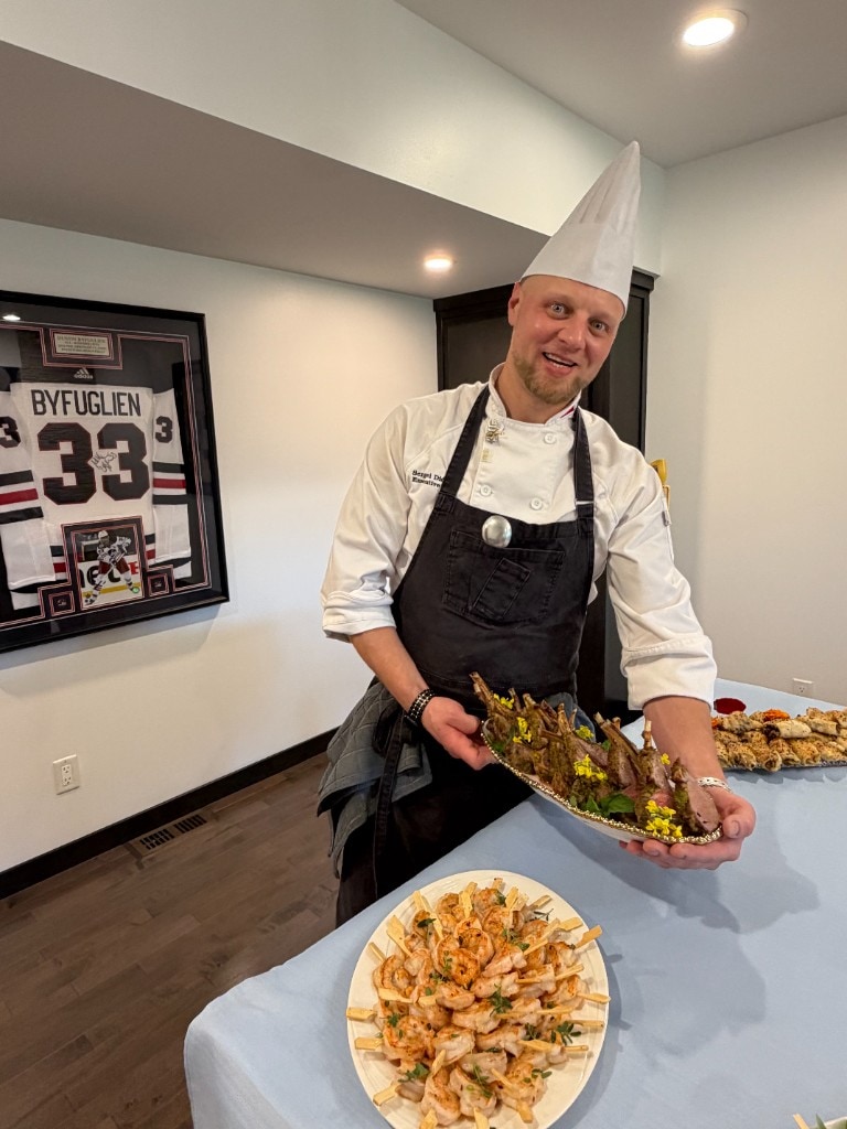 Chef Sergei Didenko presenting platters of lamb and shrimp